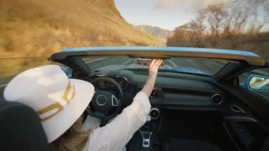 Üstü açık modern araba arka koltukları manzaralı okyanus kıyısında araba süren şık bir genç kadın. Cabriolet 'teki egzotik Hawaii adasını çatısız gezen mutlu gezgin. Açık hava macera yaz tatili