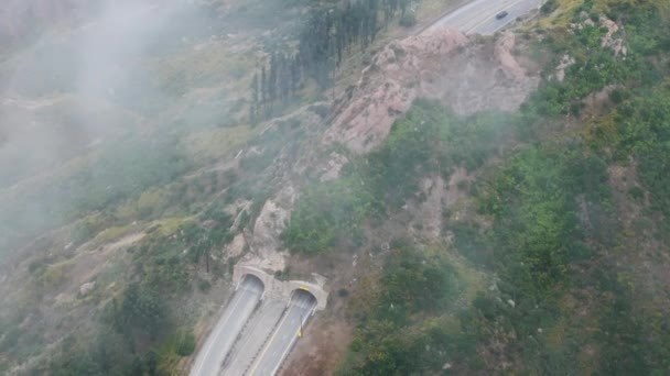 在美国加利福尼亚州洛杉矶郊区马利布的卡南路上 鸟瞰着飘过隧道的雾气云 早上穿过绿色圣塔莫妮卡山脉的高速公路的航拍 4K段 — 图库视频影像