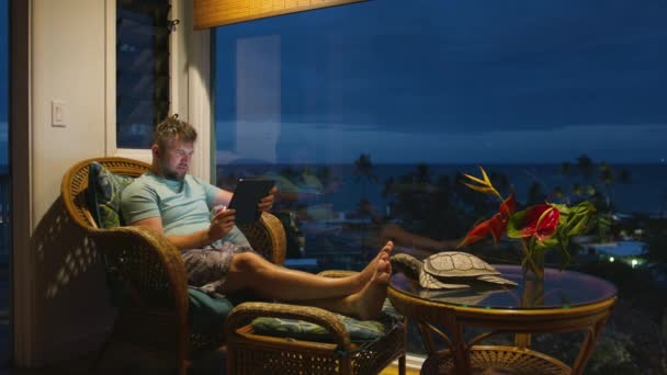 在热带岛屿度假时 商人在网上远程工作 深夜时分 在平板电脑屏幕电子邮件或社交媒体博客上释放男性打字功能 专心致志的家伙看着明亮的技术装置屏幕 — 图库视频影像