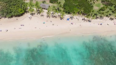 Cennetin arka planında tatildeyiz. İnsansız hava aracı insanların üzerinde egzotik bir adada yaz tatilinin tadını çıkarıyor. Hawaii adalarındaki Oahu Adası 'ndaki tropik bir sahil. ABD turizmi