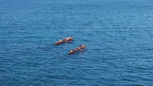深い青い緑の海水4Kで撮影された風光明媚な水活動 アウトリガーカヌーで航海する人々の頭上ショット 伝統的なハワイのカヌーをボートで競うアスレチックチームの空中ビュー — ストック動画