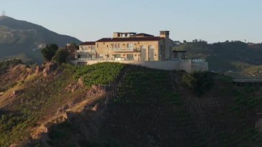 Malibu, California, ABD 'deki özel üzüm bağlarının ve şaraphanenin insansız hava aracı görüntüleri. Günbatımında Malibu Rocky Oaks Estate Vineyard 'ın evi. Şarap endüstrisi ve iş konsepti, 4K görüntü