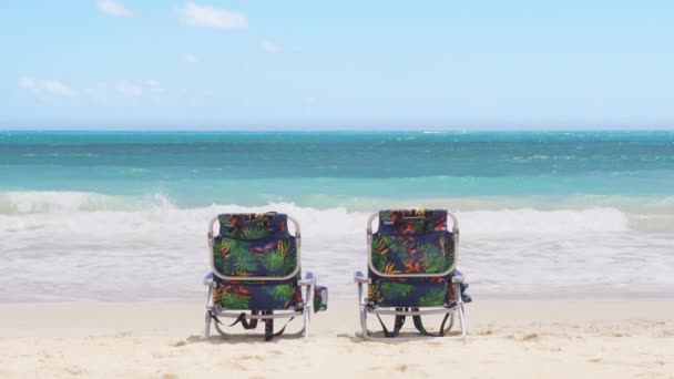 两把空的彩色海滩椅子面对着美丽的淡蓝色大海 在夏威夷岛4K有蓝天的电影背景 暑假背景 天堂岛海滩上的放松概念 — 图库视频影像