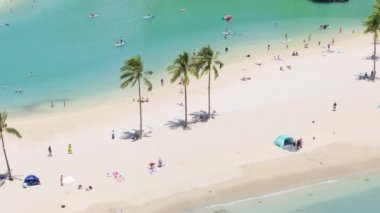 Beyaz plajda güneşlenen turistler ve Oahu 'daki mavi gölcükler. Aileler yazın tadını çıkarırlar. Waikiki tatil beldesi geçmişi. Manzaralı tropik Hawaii adalarında seyahat eden mutlu insanlar