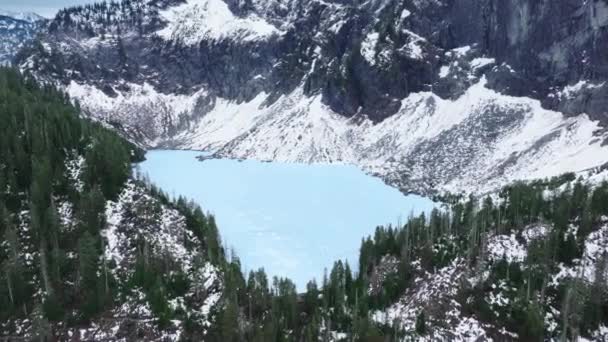 在常绿森林的雪岩山顶上 4K的空中景观冻结了宁静的湖水 北喀斯喀斯山脉的电影 华盛顿自然高山指数的高峰 冬季山景全景 — 图库视频影像