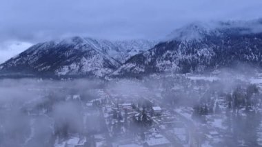 Bavyera köyünde tatil zamanı. Arka planda Cascade Dağları ile Leavenworth 'da Kış Harikalar Diyarı. Havacılık kış sezonu, Leavenworth Washington USA. Kışın bulutların arasında uçan drone