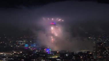 Geceleri bulutların içinde renkli havai fişekler patlıyor. Aydınlatılmış gözlem kulesinin etrafında havai fişek gösterisi. 2024 yılının gece kutlamalarında havai fişek gösterisi. Seattle 'da güzel bir havai fişek gösterisi