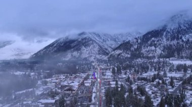 Hava aracı kış akşamında bulutların içinde uçuyor. Bavyera köyünde tatil zamanı. Arka planda Cascade Dağları ile Leavenworth 'da Kış Harikalar Diyarı. Havacılık kış sezonu, Leavenworth Washington USA