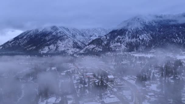 在巴伐利亚村度假 叶文沃斯冬季仙境 背景是喀斯喀特山脉 空中冬季 利文沃思华盛顿美国 冬夜的无人机在云中飞行 — 图库视频影像