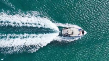 Oahu adası sahilinde okyanus üstü gemi gezisi. Hawaii aktif turizm geçmişi. Okyanustaki küçük bir teknede turistik bir eğlence. Küçük gemi hızla hareket ediyor. Beyaz köpüklü dalgaların izini bırakıyor. Yeşil suda kuyruk.