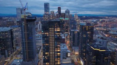 Geceleri Seattle finans sektörü. Renkli günbatımı gökyüzünde iş geçmişi. Washington 'ın alacakaranlık silueti. Günbatımının hava görüntüsü Seattle City USA 4K. Gün batımı sahnesinde şehir manzarası