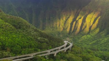 Cennet adasında yol konsepti yeşil yemyeşil ormanlarla kaplıdır. Güneş doğarken yeşil dağlarda manzara yolu. Oahu Adası, H3 otoyolunun destansı rotası. Güzel doğa Hawaii adası tropikal manzarası