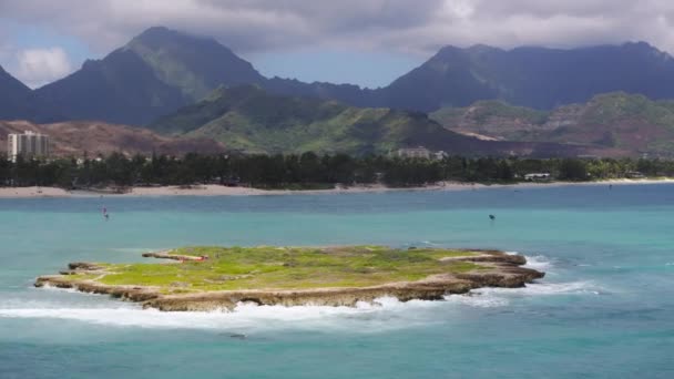 動きの背景に美しいハワイの島の風景 雲の中の高い緑の山 自然保護区のある小さな平らな緑の島を飛行するドローン カイルア湾のポポイア島の空中ビュー — ストック動画