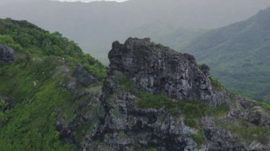 İnsanlar tehlikeli sarp kayalıklarda okyanus üzerinde yürüyüş yapıyorlar. Kahekili Tepesi 'ndeki Sahne Sinen Aslan Yolu. Oahu adasında açık hava macerası. Vahşi doğayı keşfeden aktif turistler. Tropik Hawaii ormanları