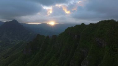 Bulutlu bir günde nefes kesici volkanik dağlar. Hawaii 'ye seyahat. Bulutlu Kualoa dağ sırtı üzerinde dramatik hava manzarası. İnsansız hava aracı yeşil orman manzarasının üzerinde Jurasik doğa gibi