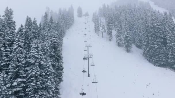 スティーブンスパススキーリゾートワシントンのスキーチェア 激しい雪の嵐の間に椅子の上昇に乗っているスキーヤー スティーブンスパス 冬季スキーリゾート 冬の雪に覆われた雪山の丘 — ストック動画