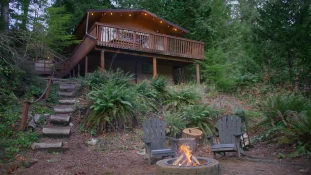 野外周末出游 在神奇的华盛顿森林中的木制小木屋 着火的森林在火坑里燃烧 后面是木制的小木屋 常绿山林中的乡村住宅 — 图库视频影像