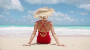 Kırmızı mayo giymiş, saçaklı hasır şapkalı mutlu dansçı kadın. Plaj tatili geçmişi. İnsanlar güzel mavi okyanuslardaki cennet adasına seyahat ederler. Hawaii Oahu ABD Yaz Turizmi