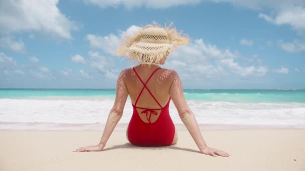 旅游概念动作缓慢 后视镜下的女人穿着红色泳衣 戴着花边草帽欣赏大海 电影海滨度假背景 夏天人们在美丽的蓝海中旅行到天堂岛 — 图库视频影像