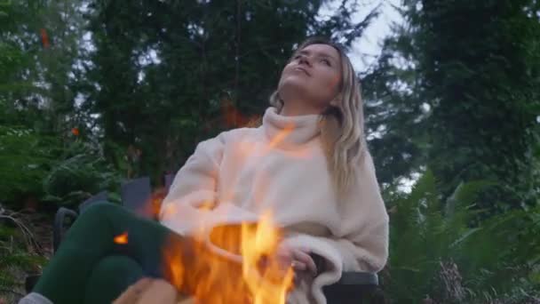 一个悠闲的女人在燃烧的火堆中享受大自然之旅的画像 在周末出游时焚烧篝火时让女性保持冷静 在美国背景下的绿云杉森林 游客在户外燃起篝火时感到满意 — 图库视频影像