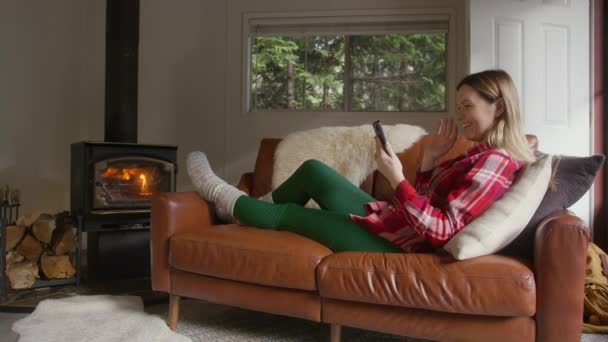 Mujer Usando Cámara Móvil Cabaña Forestal Calentándose Estufa Leña Personas — Vídeo de stock