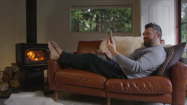 Homem Usando Câmera Móvel Aquecendo Fogão Lenha Confortável Cabine Floresta — Vídeo de Stock