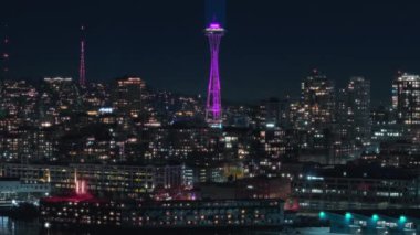 Seattle şehir merkezindeki gece manzarası. Modern şehir manzarası geceleri aydınlatılır oldu. Mor ışıklı gözetleme kulesiyle sinematik gece manzarası. Seattle Washington 'ın ana simgesi.