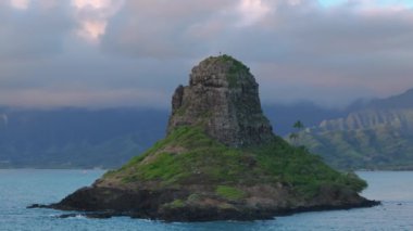 Hareketli arka planda Çinli adam adası antenleri. Oahu Adası Turizmi. Manzaralı doğa manzarası. Yağmurlu günlerde yeşil dağları olan Mokolii volkanik adasının etrafındaki dramatik hava. Kualoa 'da sinematik bulut.