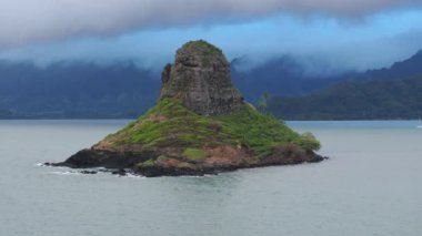 Mokolii volkanik ada dönüm noktası. Oahu Adası turizm geçmişi. Manzaralı doğa manzarası. Yaz gezisi. Yağmurlu bir günde Çin adası havası. Kualoa çiftlik parkının tepesini kaplayan sinematik bulut