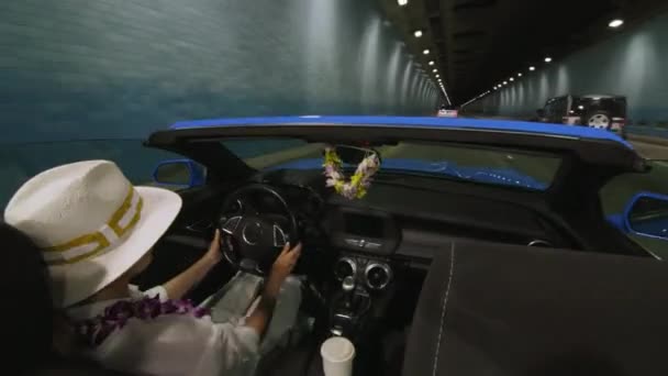 現代の未来的なトンネルで白い帽子の運転車の旅行者の背部座席の眺め オアフ島を探検する女性ドライバー 安全コンセプト4K 山トンネルで高速コンバーチブルを運転する女性観光客 — ストック動画
