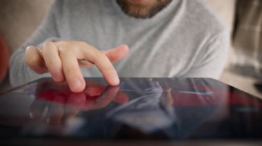 Modern teknolojiyi kullanan insanlar. İnternette erkek eli kaydırma sitesini kapat. Evde büyük tablet bilgisayar kullanan bir adam. Araba resimlerini incelemek için erkek parmakları kablosuz tablette ekrana dokunuyor
