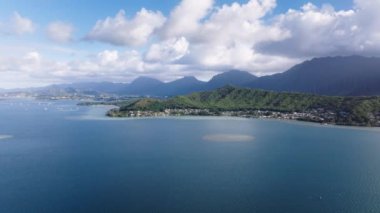 Hawaii 'deki Oahu Adası sahil şeridinde sinematik doğa manzarası. Güneşli bir günde Kahaluu yerleşim bölgesi havadan izleniyor. Tropikal adada sığ sular. Güzel deniz manzaralı mavi Pasifik Okyanusu