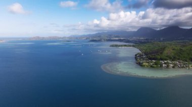 Güneşli bir günde Waikane 'in küçük kasaba manzarası. Hawaii 'deki Oahu Adası sahil şeridinde sinematik doğa manzarası. Tropikal adada sığ sular. Derin mavi Pasifik okyanusuyla güzel bir deniz manzarası