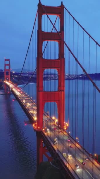 垂直录像 旧金山的地标在日落的阴天 空中俯瞰着金门大桥和城市的天际线 蓝天夜间照明红桥的电影无人机画面 — 图库视频影像