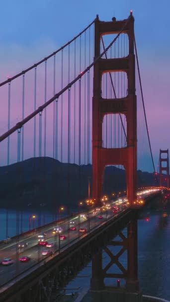 垂直录像 金门大桥在粉色夕阳西下的空中景观 蓝色太平洋水面上的红桥上 黄昏时分 天空一片朦胧 美国加利福尼亚州旧金山湾 — 图库视频影像