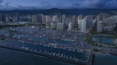 Waikiki kıyı koyunda güzel bir liman manzarası var. Şehir ışıkları mor gün batımında Hawaii. Honolulu şehir merkezinde, pembe günbatımında. Manzaralı Waikiki silueti manzarası. Şehir merkezinin gece manzarası Oahu