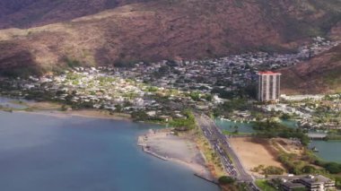 Honolulu banliyö kasabası Hawaii dağlarının manzaralı tepelerine yuva yapmış. İkonik Hawaii Kai yerleşim bölgesi. Okyanusa bakan dik tepelerde evler inşa edilir. Oahu Adası 'nda emlak geçmişi var.