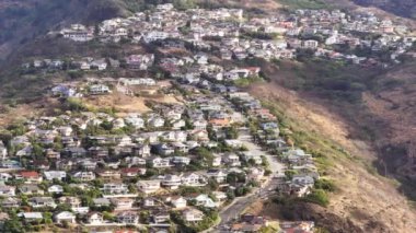 Honolulu banliyö kasabası Hawaii dağlarının manzaralı tepelerine yuva yapmış. İkonik Hawaii Kai yerleşim bölgesi. Okyanusa bakan dik tepelerde evler inşa edilir. Oahu Adası 'nda emlak geçmişi var.