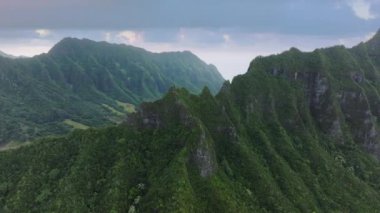 Jurassic volkan doğası olan Kualoa parkı. Dik tropik dağ sırtlı Hawaii adası kıyı şeridi. Jura dönemi manzaralı yeşil orman dağları. Kasvetli yağmurlu bir günde dramatik doğa manzarası