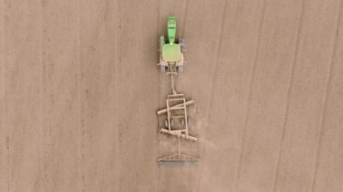 Hemen yukarıda, bir traktör, bir sonraki tarımsal aşama için bir alan hazırlarken, gerekli toprak hazırlıklarını yaparken kameraya yakalanır. Çekim 4K. 