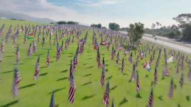 Bir İHA hızla gökyüzünde dolaşarak Pepperdine anıtsal bayraklarının dokunaklı bir görüntüsünü sunuyor, 9.11 'e huzurlu bir saygı duruşu. Çekim 4K. 