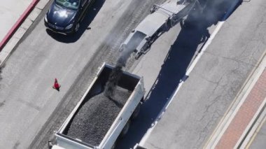 Los Angeles, Kaliforniya, ABD, yeniden yüzeye çıkış süreci Mart 4: İşçiler, beyaz bir çöp kamyonu ve kaldırım makineleriyle asfalt kaldırım operasyonlarının şehir sokaklarında yükseltilmesi. Çekim 4K. 