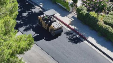 Makinelerin ve işçilerin şehir genişleme çabalarıyla meşgul olduğu bir yol şantiyesinin kuş bakışı görüntüsü. Çekim 4K. 
