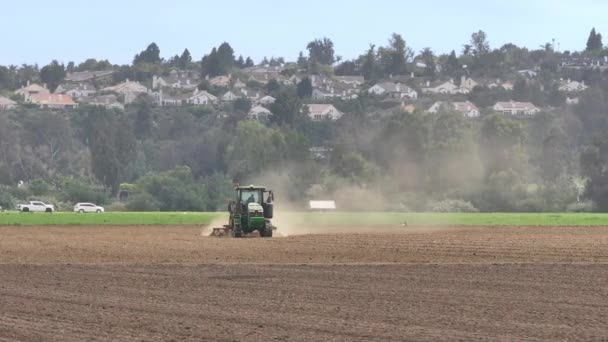 Ein Traktor Pflügt Vor Der Kulisse Eines Wohngebiets Die Felder — Stockvideo