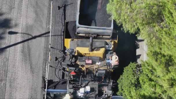 在晴朗的天空下使用沥青铺设设备拍摄城市道路建筑工人的高程视图 影像4K 免版税图库视频