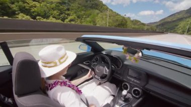 Orkide kurşunlu gezgin ve çatısı olmayan beyaz şapkalı gezgin. Rüzgarın ve yaz tatilinin keyfini çıkarmak için. Yeşil dağ manzaralı Oahu adasını keşfeden mutlu bir kadın.