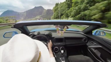 Gezgin, yeşil dağlarla Oahu adasını keşfediyor. Açık hava manzaralı üstü açık bir araba. Yaz tatilinde Cabriolet araba kullanan Orkide Lei ve beyaz şapkalı bir kadın. Özgür hisseden kız