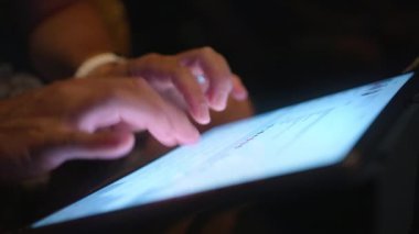 Gece geç saatlerde tablet ekranda yazı yazan erkek elleri veya sosyal medya blogu içeriğini kapat. Modern teknik cihazın parlak ekranını kapat. İnternette çalışan iş adamı, kablosuz internet 4K