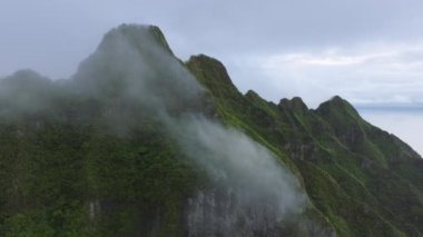 Bulutlu bir günde Kualoa çiftlik parkı. Yağmurlu bir günde sinematik tropikal doğa dağ manzarası. Yüksek dağların tepesinde bulut. Dramatik kopya arkaplanı. Yeşil ormanların zirvesinin manzarası