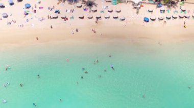 Mavi suda yüzen ve altın güneş altında güneşlenen insanlar. Güzel Waikiki plajının yukarıdan manzarası. Cennet adası doğası. Yaz tatilinin uzay duvar kağıdını tropik Hawaii 'de kopyala